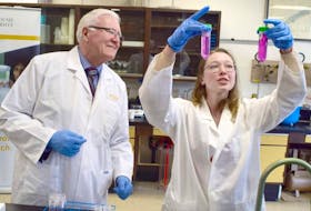Graduate student Carolyn Mann shows Bill Casey, Member of Parliament for Cumberland-Colchester, a test for determining the amount of nitrogen in soil.