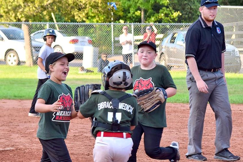 Embracor Medical pitcher Owen Paris, left, celebrates with teammates after a 5-3 victory over Fundy Textiles on Thursday in Game 2 of the BHTMBA mosquito division final series.