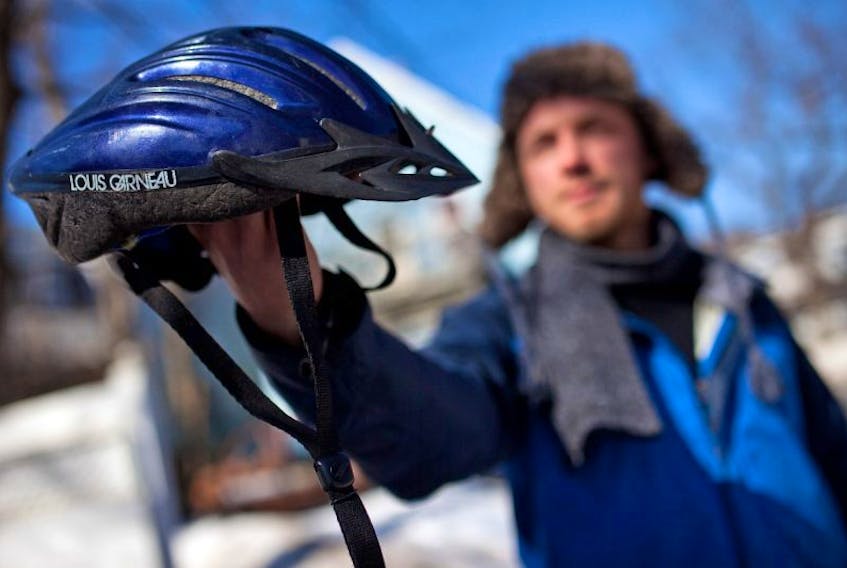 Tristan Cleveland holds a bike helmet.