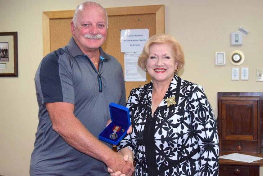 Valley resident Gerry Tucker is seen being presented with the Governor General’s Sovereign’s Medal for Volunteers from Colchester County Mayor Christine Blair.