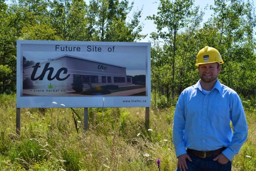 Evan Price, president of The Truro Herbal Co., stands in front of a billboard sign in the Truro Business Park, which depicts how Nova Scotia’s first medical marijuana production facility is going to look.