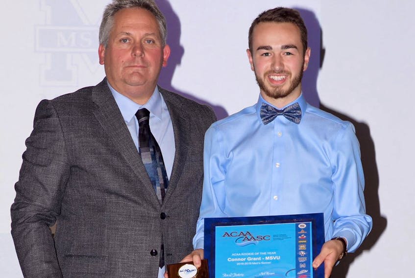 Neil Hooper, left, president of the Atlantic Collegiate Athletic Association, presents the 2018 Rookie of The Year Award to Connor Grant.