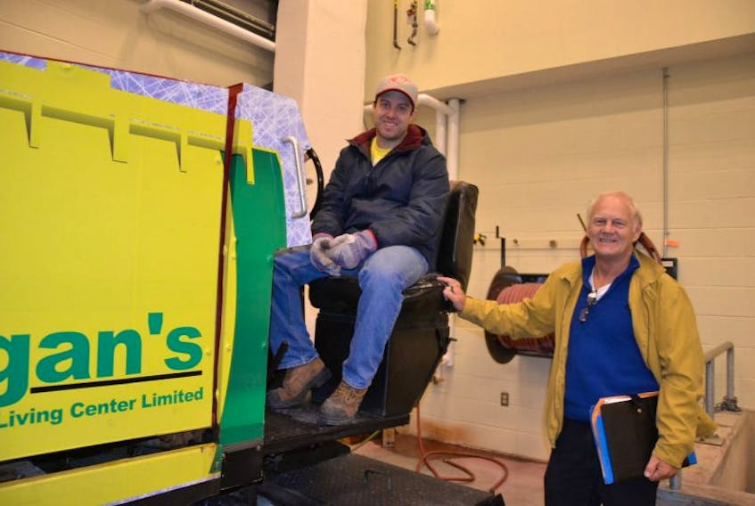 Kyle Mulley, an Emera Centre Northside Employee, is shown with Wayne Ryan, one of the organizers of the Tokyo Lloyd Memorial Hockey Tournament, are shown with the broken Zamboni at the Emera Centre Northside. Tournament proceeds will help to buy a new Zamboni for the Emera Centre.