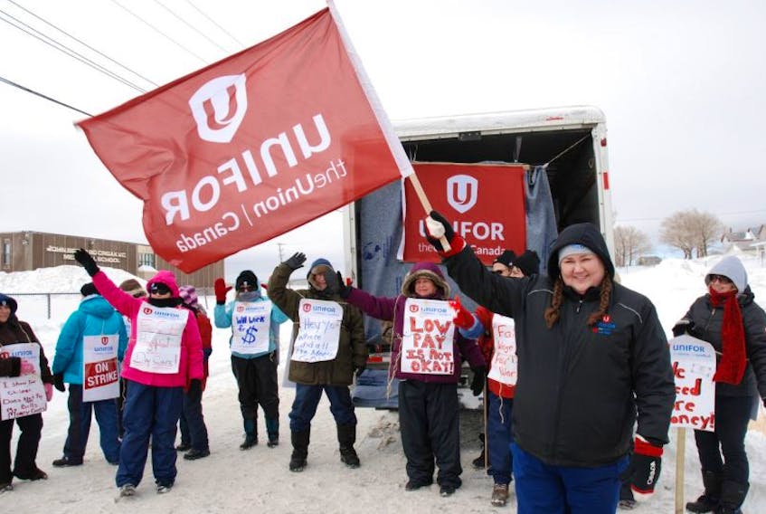 Susan Gill (right) president of Unifor Local 4600, waves the union flag at passing motorists while out supporting workers of the Town Daycare in Glace Bay The 14 daycare workers went out on strike at 7 a.m. Tuesday, March 17.