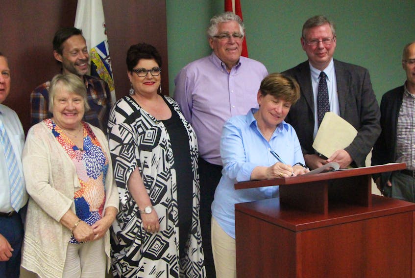Antigonish Town Council and Eastern District Planning Commission (EDPC) director John Bain (second from right) look on as Mayor Laurie Boucher signs a contract which, officially, has the town joining EDPC. The signing took place during council’s regular monthly public meeting June 18. Richard MacKenzie