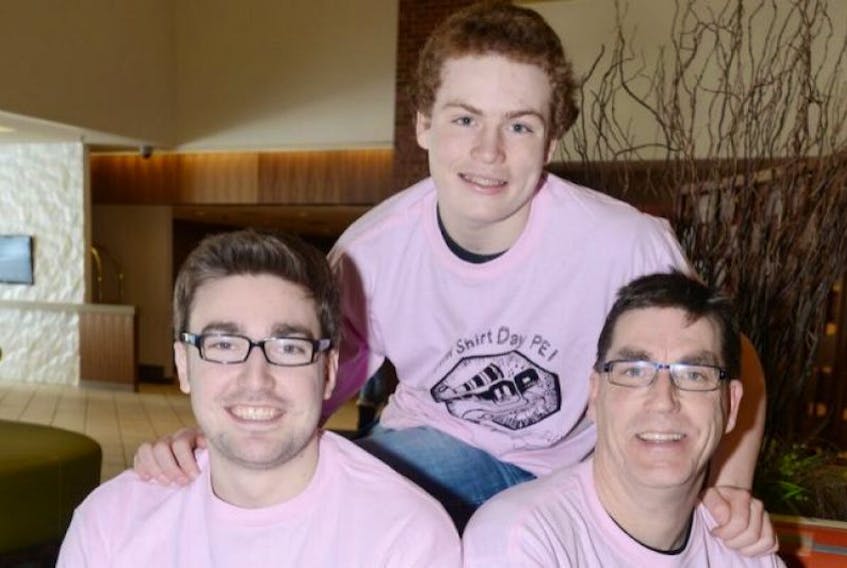 Travis Price, front left, the man behind the international Pink Shirt Day, poses with Joe Killorn and his son Dalton, both supporters of Price's anti-bullying campaign. Price is in Prince Edward Island this week to spread his peaceful message to students.
