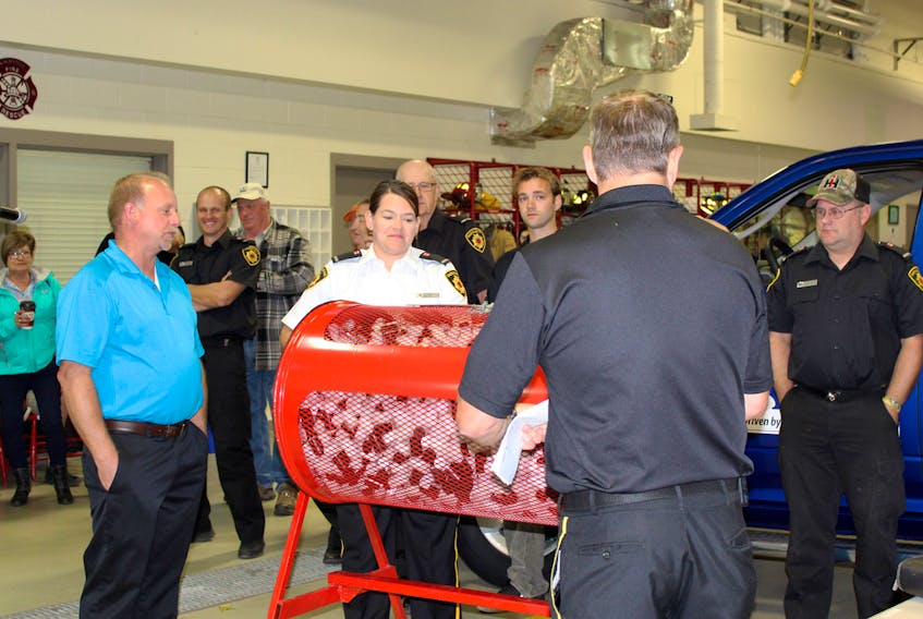 Johnny Snowdon, left, of Amherst Chrysler gets ready to pull the winning ticket on Saturday evening as Sackville firefighters Laura Thurston and Walter Allen give the drum a last spin during the truck draw on Saturday evening at the fire station.