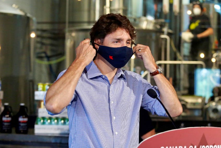 Canada's Prime Minister Justin Trudeau removes his face mask as he visits the Big Rig Brewery, which utilizes the Canada Emergency Wage Subsidy given to businesses affected by the coronavirus disease (COVID-19) outbreak, in Kanata, Ontario, Canada June 26, 2020. 