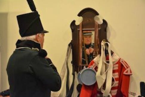 ['Artist Henry Purdy tries on a replica tunic of the Glengarry regiment from the War of 1812 at Eptek Art &amp; Culture centre. The exhibit celebrates the end of the war, in December 1814, and will be in place until the end of February.']