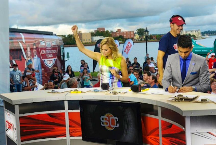 Jennifer Hedger pumps her arm to the music while she and Nabil Karim co-host an edition of TSN’s SportsCentre live from Victoria Park in Charlottetown on Thursday as part of the 2014 Kraft TSN Celebration Tour.