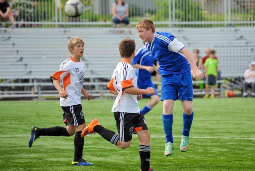 Riley Rafferty of Western, right, makes the header with two Burin Penninsula players, Jonathan Inkpen, middle, and Cameron LeRiche during Subway Boys Under-14 Provincial Soccer League play Sunday, July 13, 2014, at the Wellington Street Sports Complex.