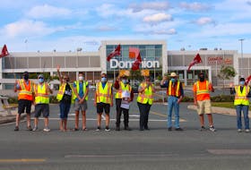 A group of Dominion employees block the entrance to the parking lot as they strike at the Blackmarsh Road location on Wednesday. Andrew Waterman/The Telegram