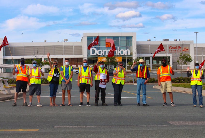 A group of Dominion employees block the entrance to the parking lot as they strike at the Blackmarsh Road location on Wednesday. Andrew Waterman/The Telegram