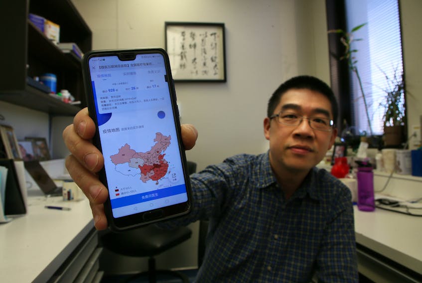 Dalhousie University professor Zhenyu Cheng displays a Sina Weibo post with the latest update on cases of coronavirus in his office at the university on Friday. Cheng is a former resident of Wuhan. TIM KROCHAK/ The Chronicle Herald