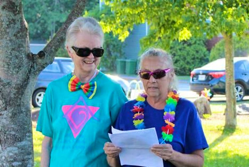 From left: Partners Wendy Annand and Alice Bent give a speech at this year’s Lunenburg Pride flag raising ceremony.
