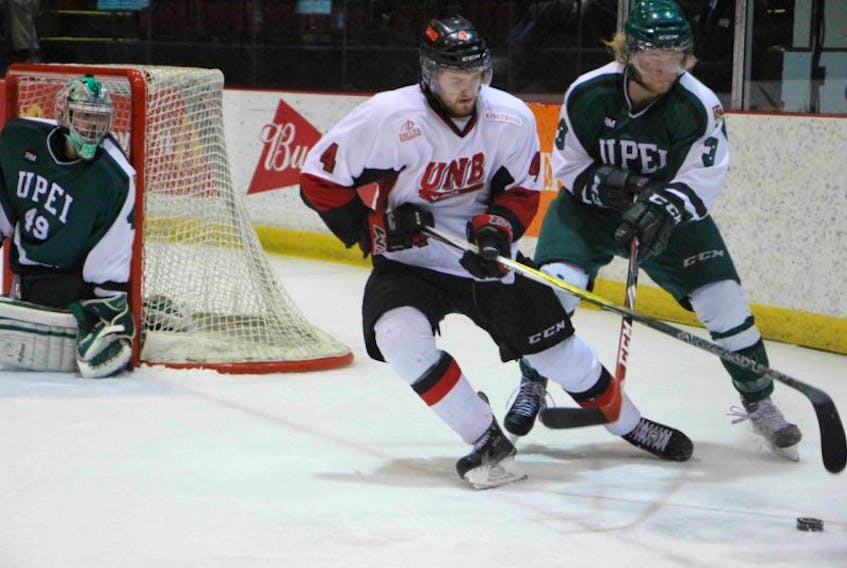 <p><span class="Normal">Sam Aulie of the UPEI Panthers battles for the puck in the corner with Jordan Murray of the UNB Varsity Reds in Game 1 Thursday of the Atlantic University Sport men's hockey semifinal. The Reds went on to take the opener 4-1.</span></p>
