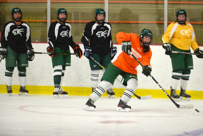 Faith Steeves, second from right, makes a pass during Monday’s UPEI Panthers practice at MacLauchlan Arena.