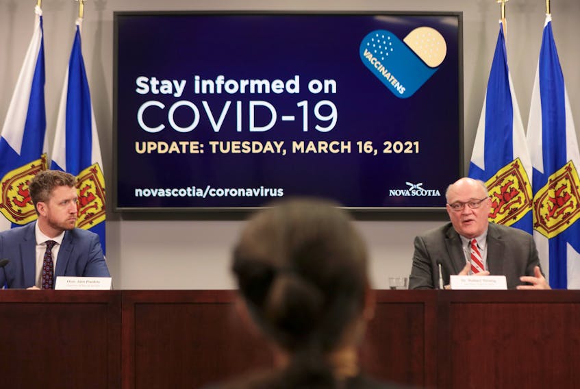 Nova Scotia Premier Iain Rankin listens as Dr. Robert Strang, chief medical officer of health, speaks at a COVID-19 briefing on Tuesday, March 16, 2021.