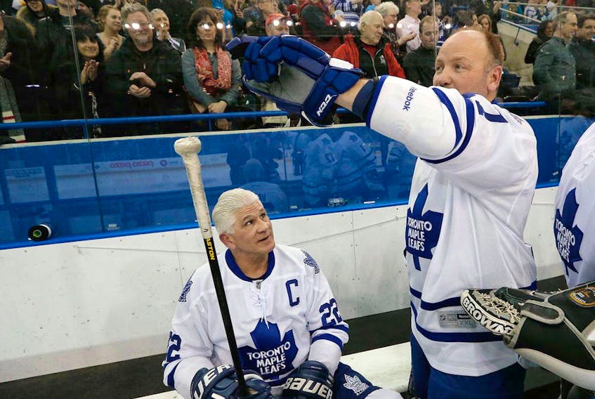 Wendel Clark and Rick Vaive (seated) play for the Toronto Maple Leafs in an alumni game. Vaive holds the franchise mark for goals with 54. (Jack Boland/Toronto Sun)
