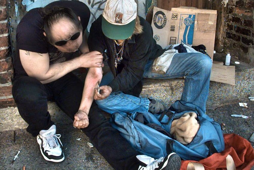 Drug addicts inject heroin on the back steps of the Washington Hotel in 2017. (Peter Battistoni/PNG FILES)