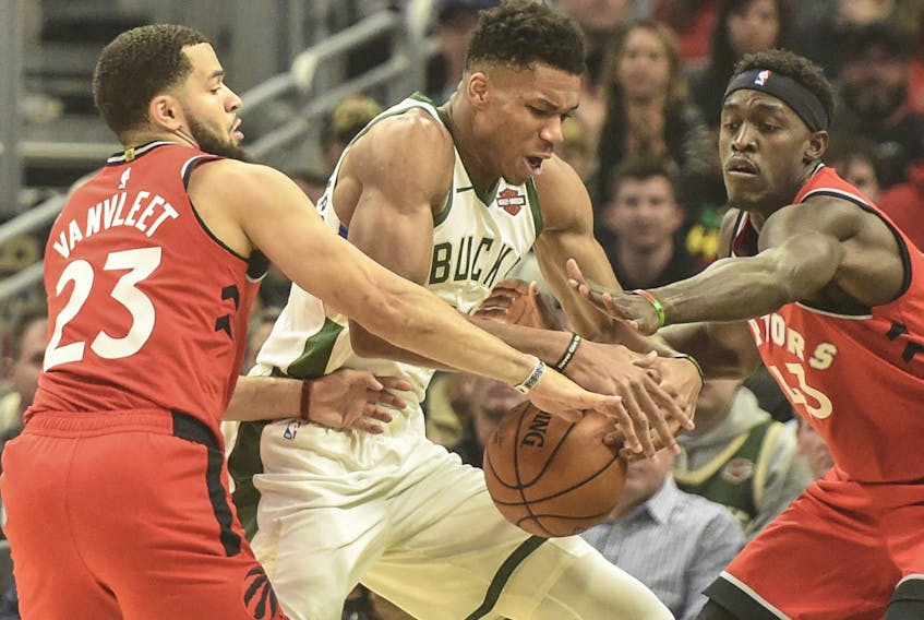 Raptors guard Fred VanVleet (left) and forward Pascal Siakam put pressure on Milwaukee Bucks forward Giannis Antetokounmpo during a game in November. (USA TODAY Sports)