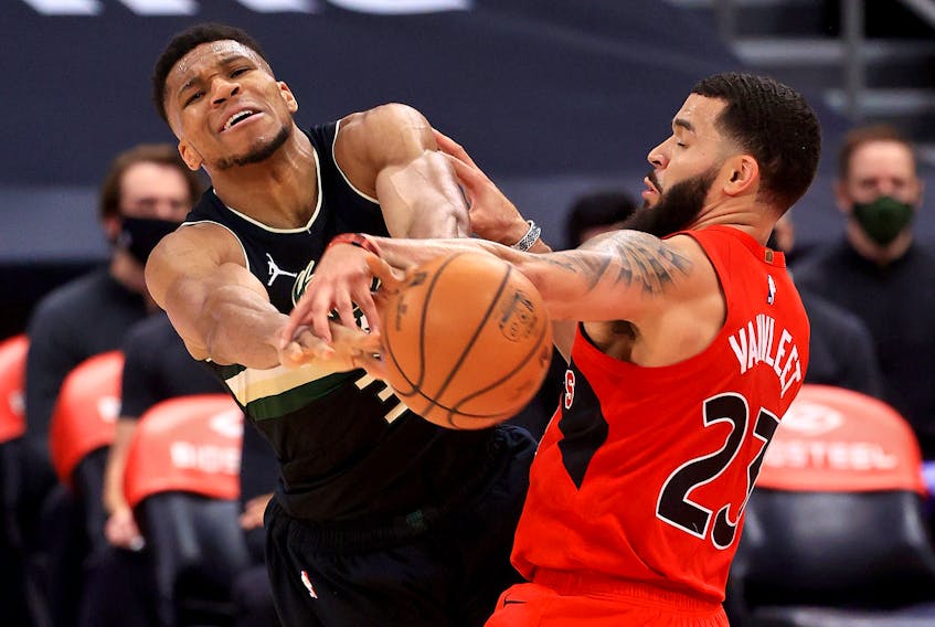 Giannis Antetokounmpo (left) of the Milwaukee Bucks and Fred VanVleet of the Toronto Raptors fight for the ball on Wednesday night at Amalie Arena.