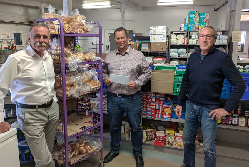 Mike MacDonald, centre, manager of Charlottetown's Upper Room food bank, accepts a $40,000 donation on behalf of Food Banks Canada from John Barrett, left, Vesey’s director of sales, marketing and development, and Gerry Simpson, vice-president of Vesey’s Seeds Ltd.