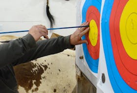 Daniel Savoie removes arrows from a target during the Soldier On archery workshop at the Cass’ Creek Archery Club in Covehead.