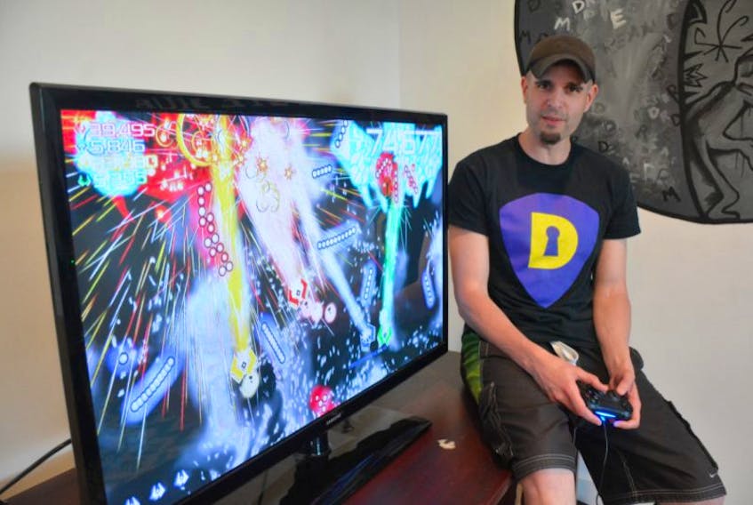 Yarmouth resident Matthew Doucette of Xona Games sits next to a screen showing the company’s latest game, Score Rush Extended, which was released on the PS4 platform last week.