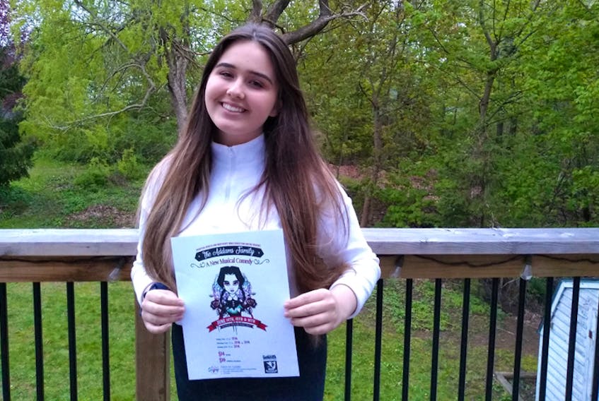 Breagha Hawley shows off a copy of the poster for The Addams Family: A New Musical Comedy. Hawley will play Wednesday Addams in the show, which will be put on by Northeast Kings students.