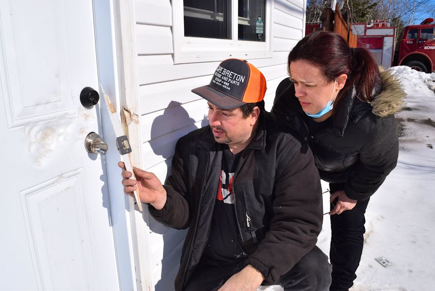 Peter Arapis, owner of PRG Diamond Sports Cards & Collectibles on Seaside Drive in Gardiner Mines, and his wife Heather Arapis, look over the damage caused by a thief who broke into the building on Sunday. Sharon Montgomery • Cape Breton Post