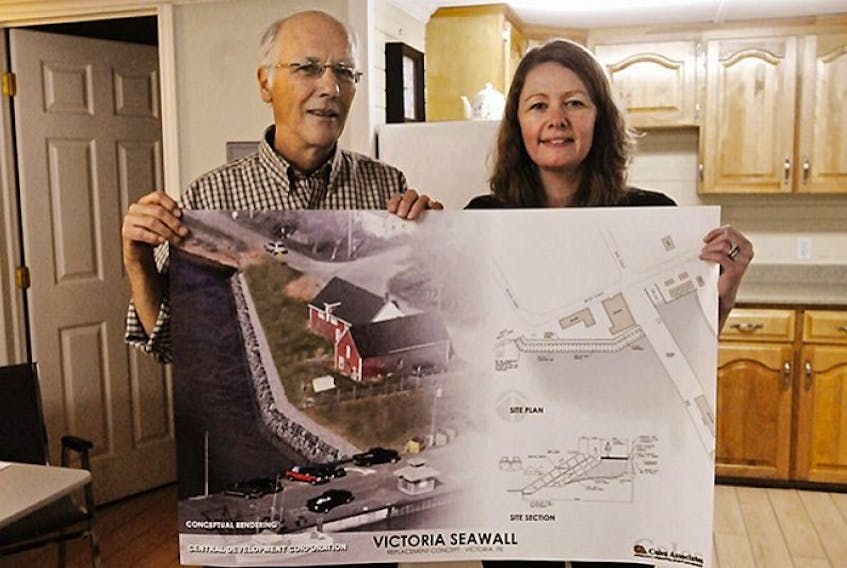 <span class="BodyText">Ben Smith, chairman of the Victoria community council, and Nicole Warren, executive director of the Central Development Corporation, hold up a plan to repair the seawall in the community. It is part of a $1.1 million dollar, three-phase community development proposal put to residents at a public meeting this week.</span>