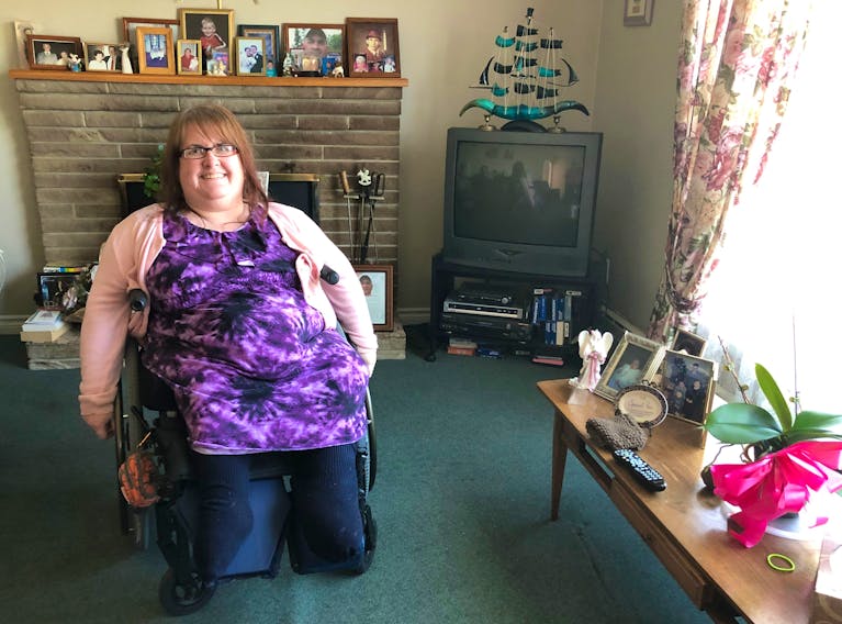 Susan Burke, 51, is surrounded by photos of her family as she sits in the living room of her Coxheath home where she grew up. NICOLE SULLIVAN/CAPE BRETON POST 