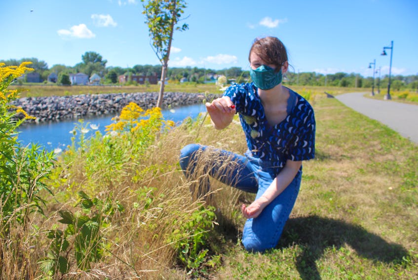 CBU student Clara Reynolds-White holds up a raspberry she picked a few feet from the pathway at Open Hearth Park. Chris Connors/Cape Breton Post
