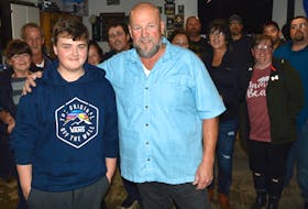 Gordon MacDonald, right, and grandson Landon MacDonald stand in front of a group of family and friends in the family’s garage on Tobin Road Saturday evening. Gordon MacDonald won election in the Cape Breton Regional Municipality’s District 1 seat, representing the communities of Sydney Mines, Florence, Little Pond, Alder Point and the neighbourhood of Tobin Road. JEREMY FRASER/CAPE BRETON POST
