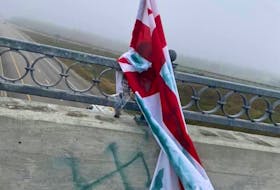 A vandalized Mi'kmaq Grand Council flag is shown on the Membertou overpass. The flag was first raised by Shauntel Paul and her husband to show solidarity with Sipekne'katik First Nation. The community faced backlash from commercial fishers in the Digby area and Paul wanted them to know they're not alone. CONTRIBUTED/FACEBOOK 
