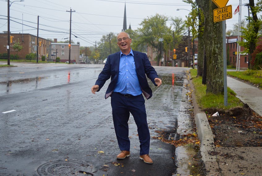 Nova Scotia NDP Leader Gary Burrill enjoys a laugh with the Cape Breton Post’s David Jala after being asked to step out further onto a very windy, but not so busy, George Street in Sydney, for a picture on Wednesday morning. During an interview with the publication, Burrill weighed in on a number of issues important to residents of the CBRM. DAVID JALA • CAPE BRETON POST