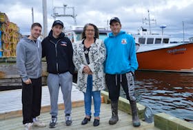 Family members stand in front of fishing boats near Ballast Grounds Fisheries at the North Sydney Wharf. Lobster fishing season begins in area 27 on Friday and fishermen are worried about the uncertainty of the season because of COVID-19. From left, Dylan MacKinnon, Scott MacKinnon Jr., Marlene Brogan and Roger Penny. JEREMY FRASER/CAPE BRETON POST