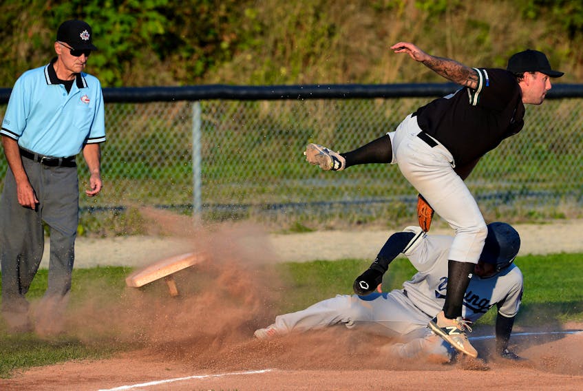 Gonzaga Vikings player Allan Saunders slides into, and dislodges, third base as Storm player Jared Power tries to make the tag during baseball action at St. Pat’s Ball Park Wednesday evening. Looking on is umpire Dave Buckingham.

Keith Gosse/The Telegram