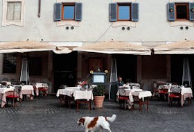  A dog passes in front of an almost empty restaurant in Trastevere area of Rome, after a decree ordered the whole of Italy to be on lockdown in an unprecedented clampdown aimed at beating the coronavirus.