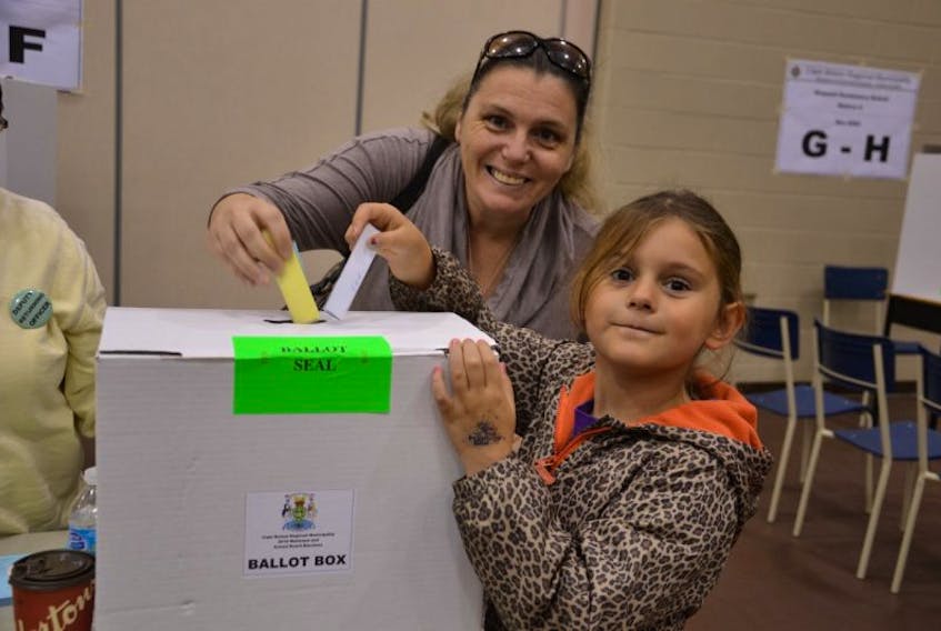 <p>Six-year-old Sierra Abromeit helped her mother Cheryl Eveleigh put her ballots in the ballot box, Saturday afternoon at Shipyard Elementary in Sydney. A steady stream of voters were casting their ballots in the municipal and school board election.</p>