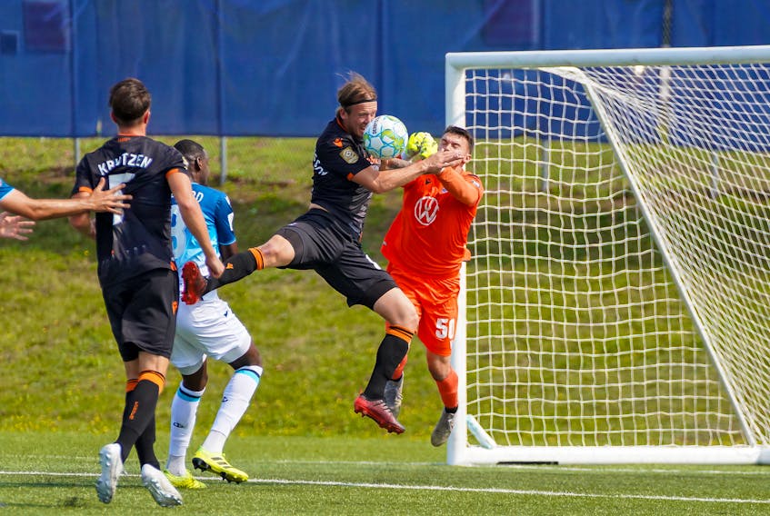 HFX Wanderers FC keeper Christian Oxner punches the ball away from Forge FC's Alexander Achinioti Jonsson during Wednesday's CPL game in Charlottetown. (Canadian Premier League)
