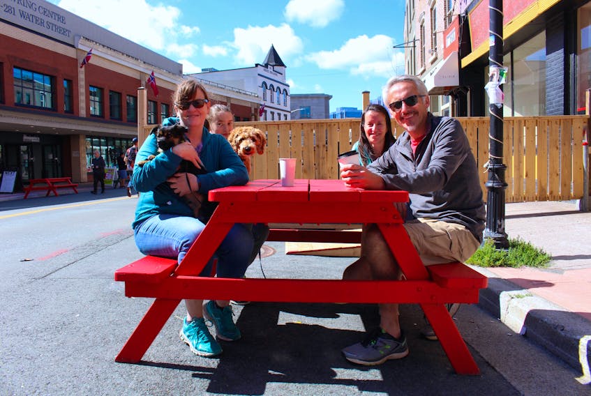 Jackie Hesson sat down for a coffee with family after a stroll from Churchill Square. She would like to see the City of St. John’s continue with the pedestrian mall past the scheduled closing date of September 7. Left to right: Jackie Hesson with dog Marley, Julia Willis with dog Cooper, Karen Willis and Keith Stapleton.  – Andrew Waterman/The Telegram