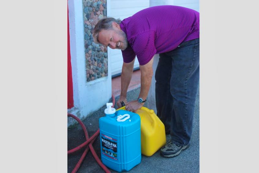 A Shelburne resident fills up his containers at the Shelburne Fire Department, saying he's been out of water for a month now.