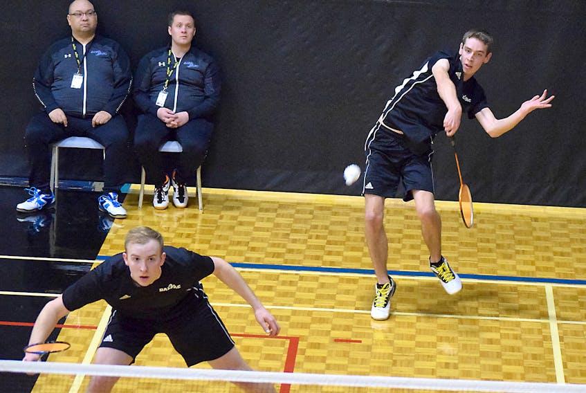 Andrew Systma, right, and Tim Trites of the Dal AC Rams play in front coaches Richard Bennicke, left, and Chris Ross at the CCAA badminton championship on Thursday at Dalhousie Agricultural Campus.
