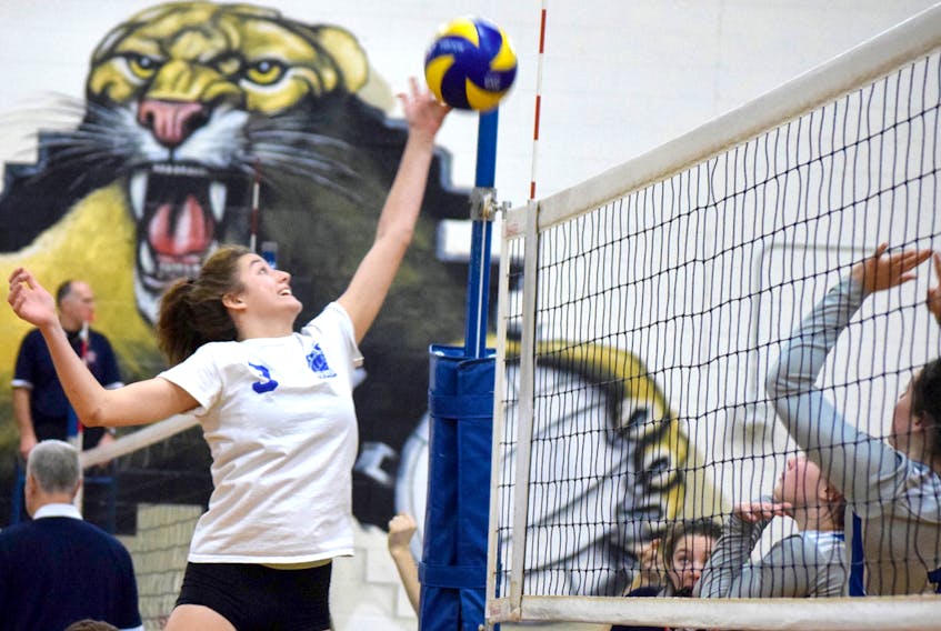 Jenna Adams of the Cougars goes up high over the net to get a touch on the ball.