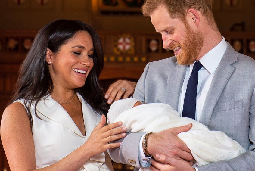 Britain's Prince Harry, Duke of Sussex (R), and his wife Meghan, Duchess of Sussex, pose for a photo with their newborn baby son, Archie Harrison Mountbatten-Windsor, in St George's Hall at Windsor Castle in Windsor, west of London on May 8, 2019.