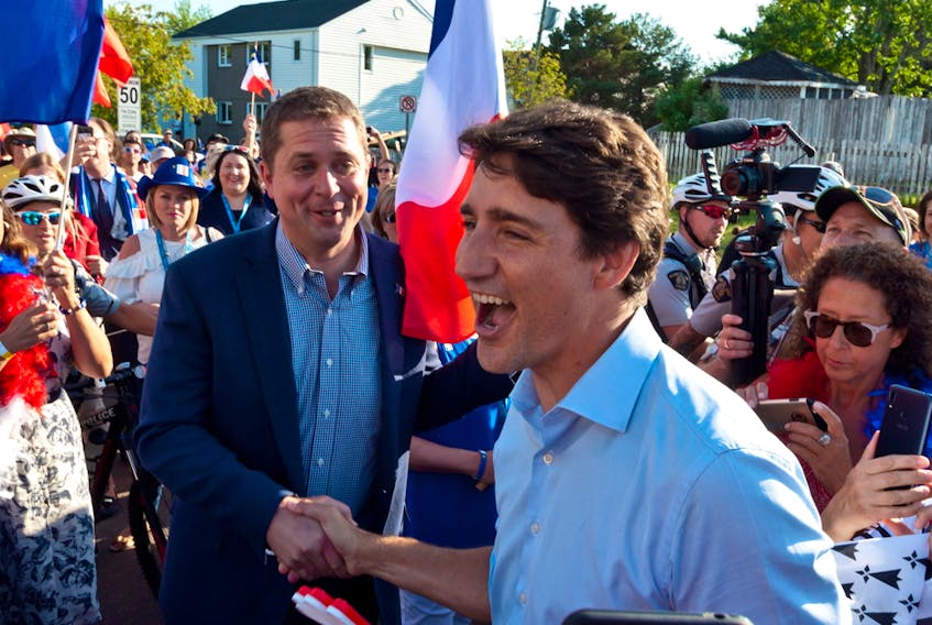 Prime Minister Justin Trudeau shakes hands with Conservative Leader Andrew Scheer while walking with the crowd in Dieppe, N.B., Thursday, Aug. 15, 2019.  