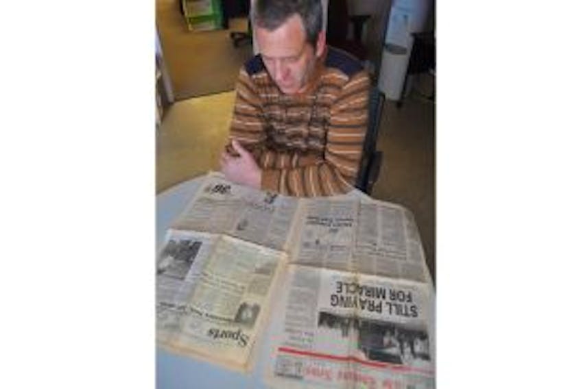 ['Robert Thompson looks over a newspaper from the week the Westray Mine exploded. ']
