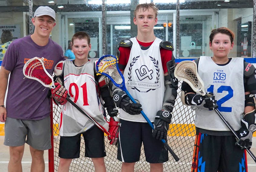 Kyle Jackson, a member of the newest NLL team, the Halifax Thunderbirds, stands with Junior Thunderbirds Travis McAndrew, Mason McNeil and Kadin Gloade following practice on Thursday in Halifax. The local trio will compete with the Junior Thunderbirds at the Junior National Lacrosse League Tournament next week in Oakville, Ont. HALIFAX THUNDERBIRDS PHOTO